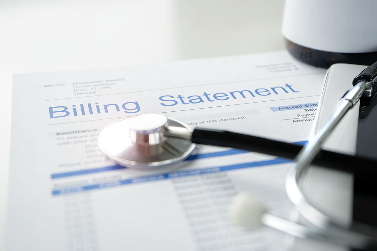 A stethoscope sits on top of a paper healthcare billing statement.| HealthDiscovery.org