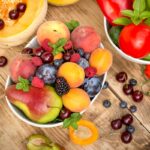 Bowls of seasonal fruit that protect against skin damage on a wooden table | Corporate Synergies
