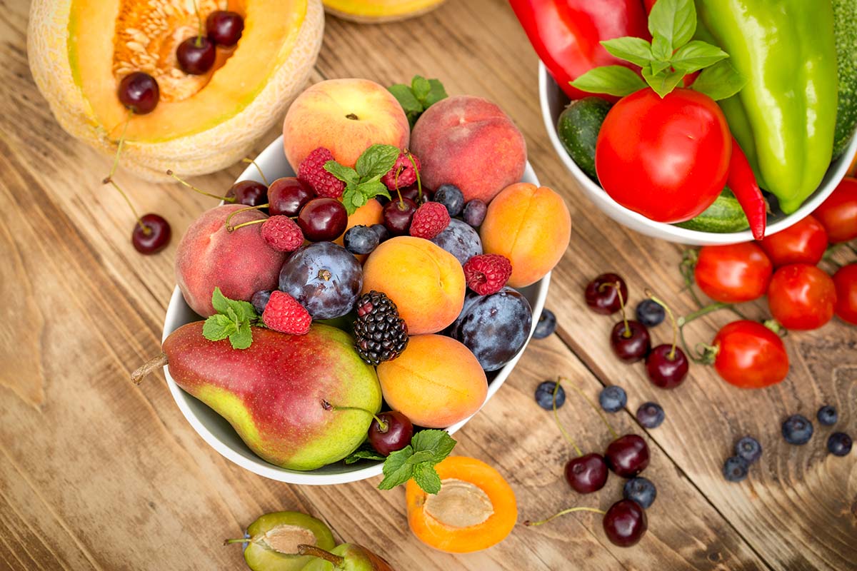 Bowls of seasonal fruit that protect against skin damage on a wooden table | Corporate Synergies