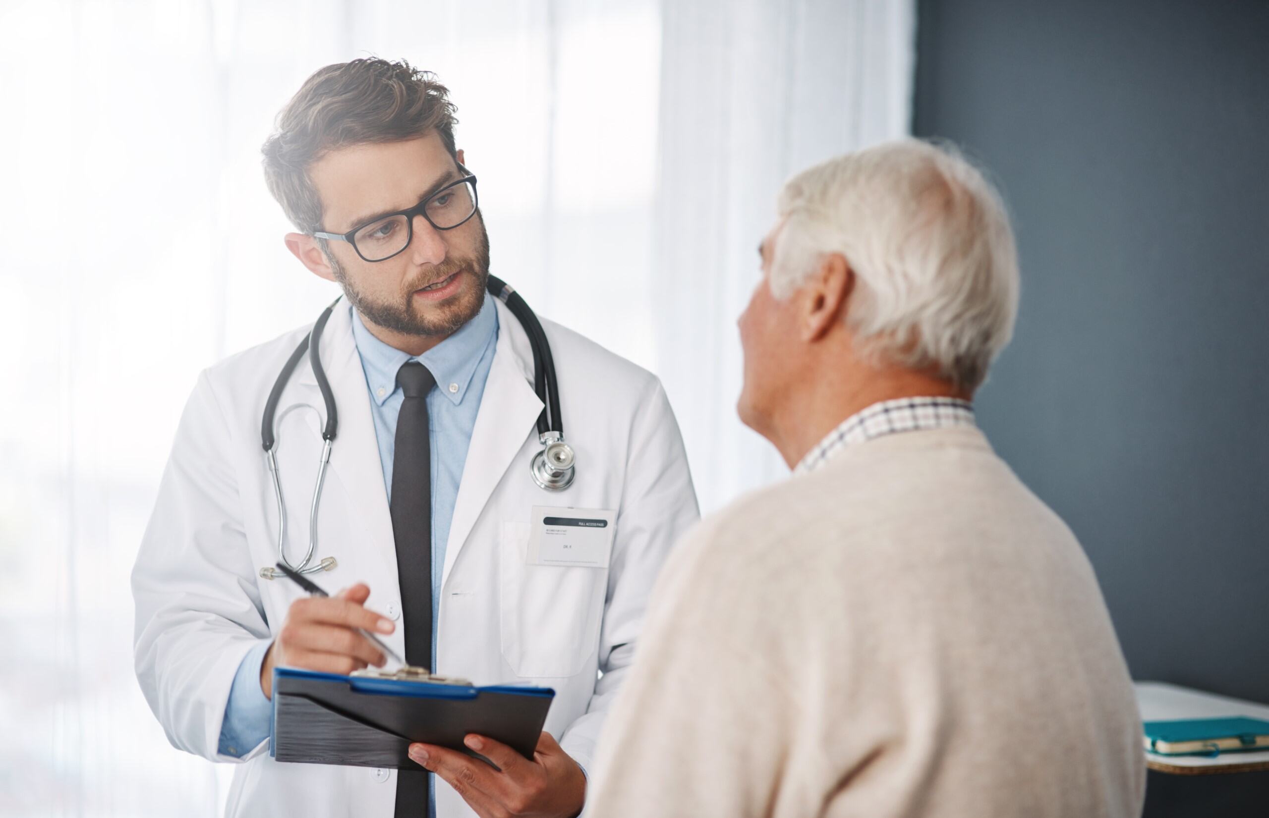 An older man discusses prostate cancer screening with his doctor | Corporate Synergies