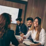 Business woman on a job interview, shaking hands with the human resources representative | Corporate Synergies