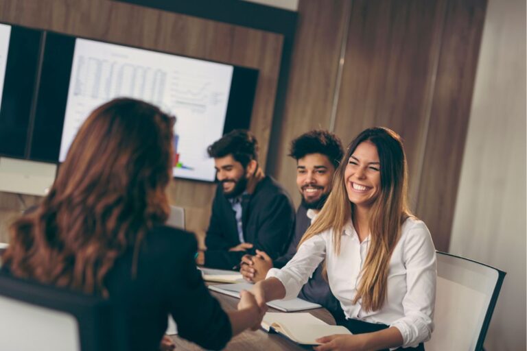 Business woman on a job interview, shaking hands with the human resources representative | Corporate Synergies