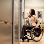 Young businesswoman in wheelchair using access card to enter office | Health issues and workplace inclusivity | Corporate Synergies