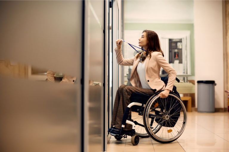 Young businesswoman in wheelchair using access card to enter office | Health issues and workplace inclusivity | Corporate Synergies