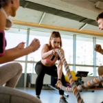 Women doing rope workout at gym with trainer as a common fitness insurance benefit | Corporate Synergies
