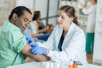 Patient receiving vaccine with health insurance | Corporate Synergies