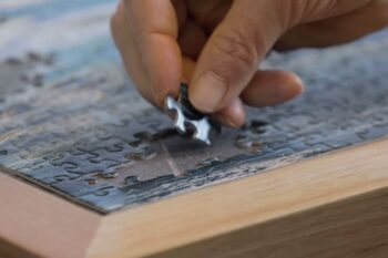 Older man completing a jigsaw puzzle for healthy aging | Corporate Synergies