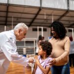Insurance-covered preventive services allow a doctor to vaccinate a low-income family at community center | Corporate Synergies