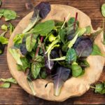 Leafy green superfood salad with spinach, arugula, romaine and lettuce in rustic wooden bowl | Corporate Synergies