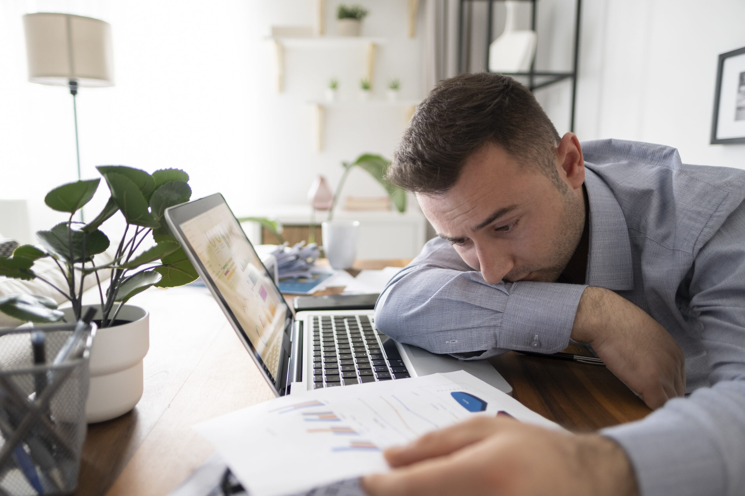 Depressed male worker at laptop thinking of ways to prevent burnout in the workplace | Corporate Synergies