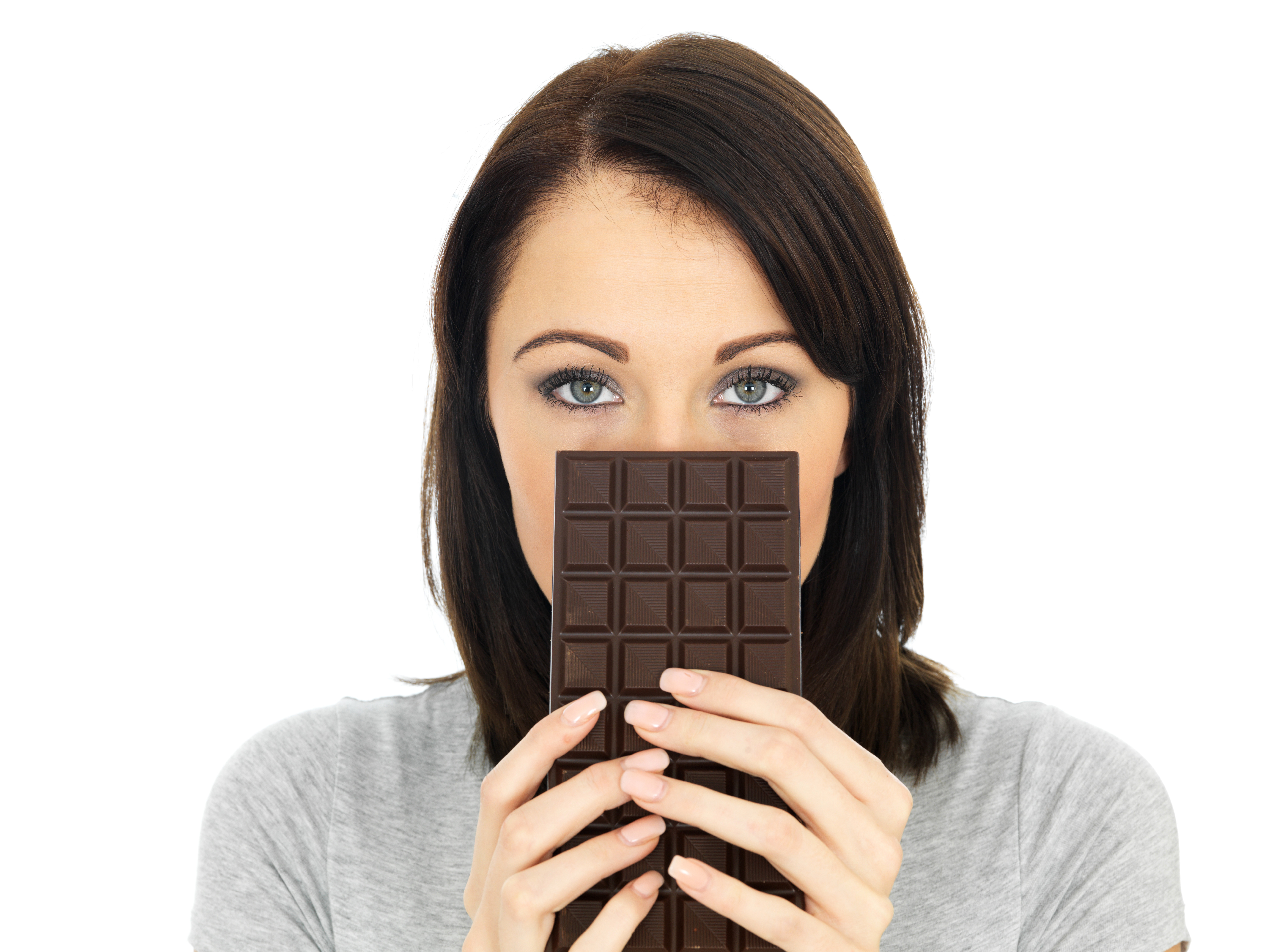 Young woman holding dark chocolate bar over her face for stress support | Corporate Synergies