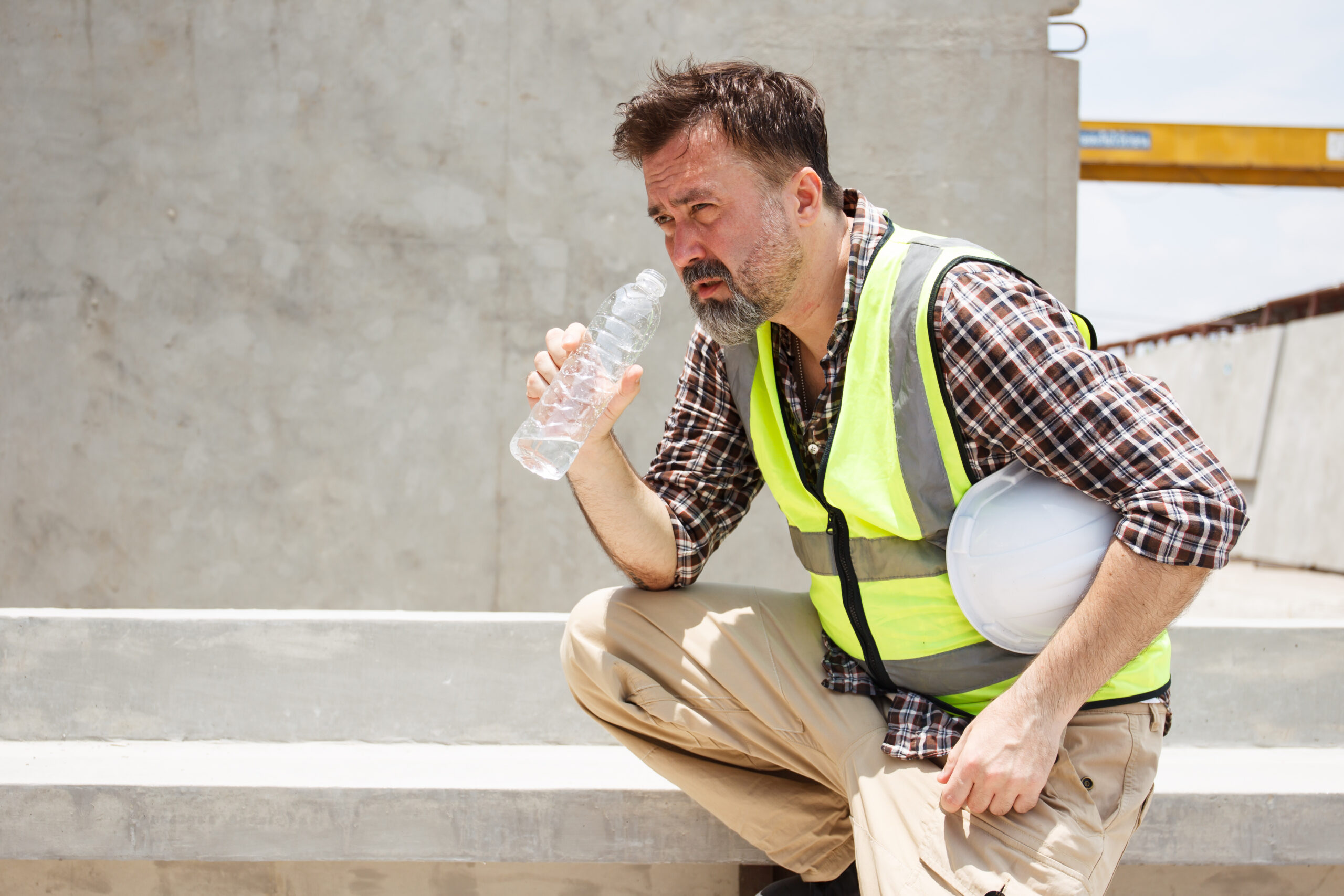 Construction worker drinking water following dehydration guide and warning signs | Corporate Synergies