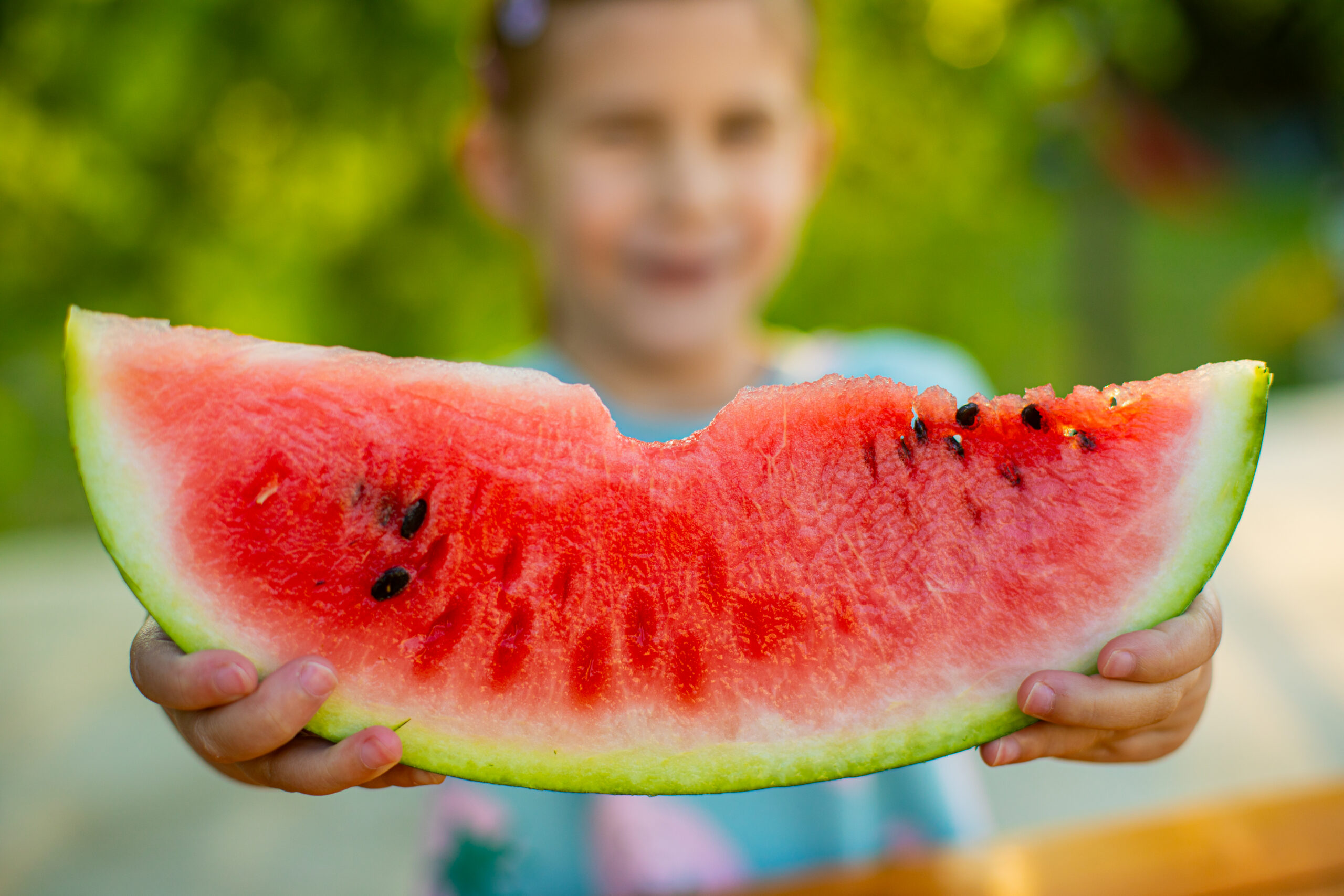 Child holding a bitten slice for watermelon superfood benefits and food high in lycopene | Corporate Synergies