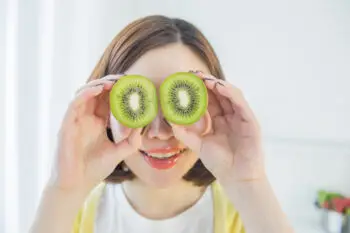 girl with superfood kiwi covering her eyes | Corporate Synergies