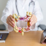 Gastroenterologist with colon anatomy model for digestive health | Corporate Synergies